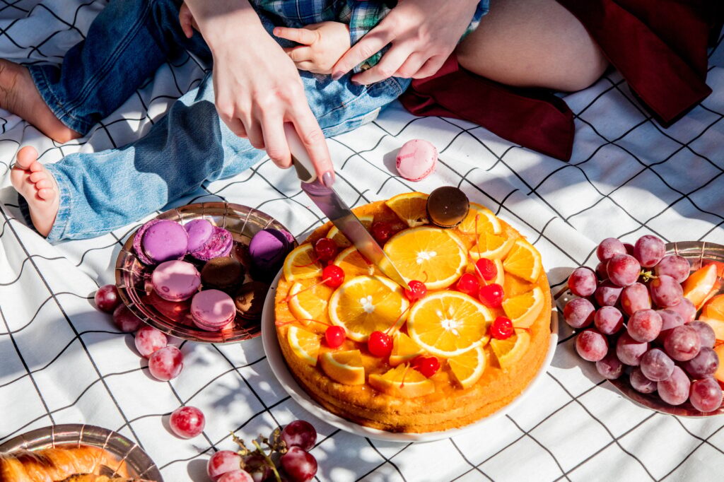 Female cut pie with oranges for a event day on picnic checked cloth