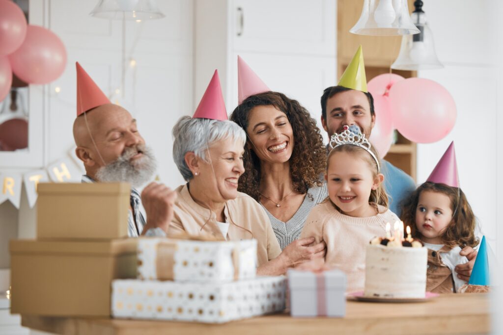 Happy birthday, gift and big family celebrate with cake in a home party, event and candles in a hou